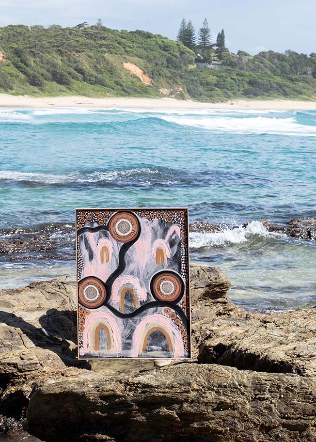 Girrwaa Print Edition standing on rocks by the ocean