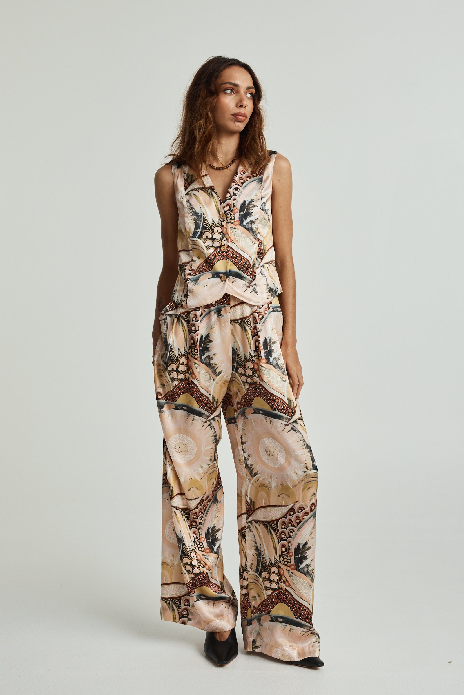 A model wearing a sleeveless, floral print, silk wide leg trouser with an elasticated back waistband and a side zipper.