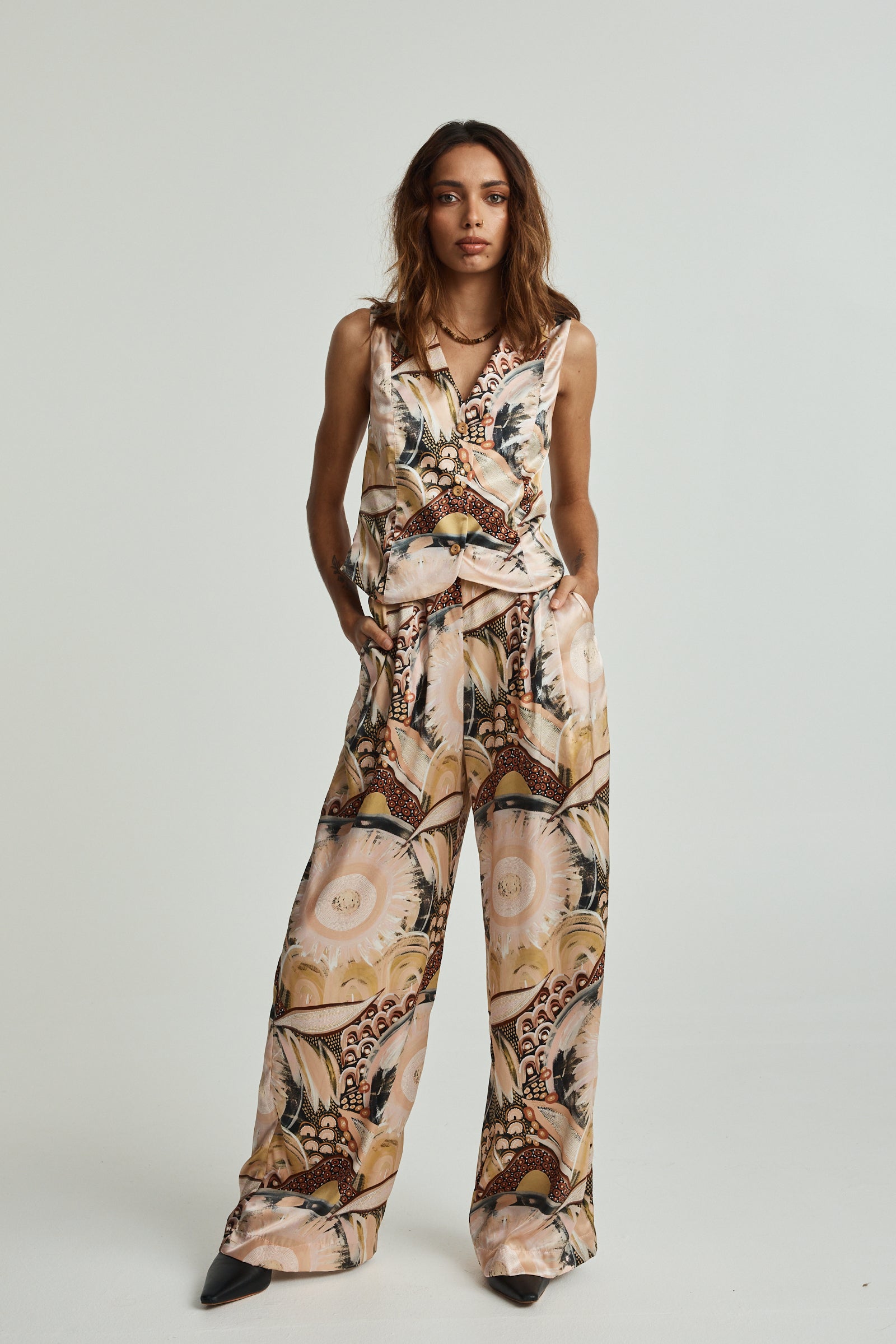 Woman wearing a patterned jumpsuit on a white background