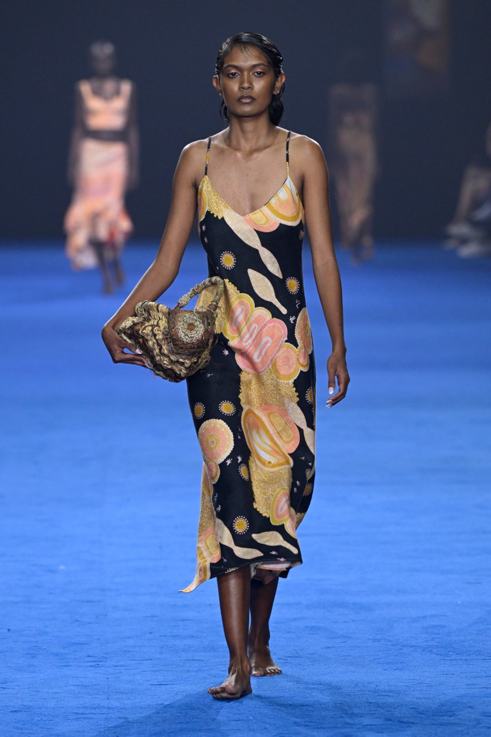 A model wearing a floral and animal patterned Yuulgarr Linen Slip Dress on the runway.